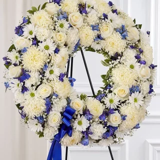 round funeral wreath of white and blue flowers