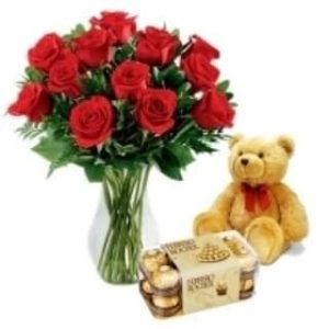 Shop same-day fresh flower delivery in Nairobi, Kenya, a Special Care bouquet of two dozen red roses, a clear vase, a teddy bear, and 16 pieces of Ferrero chocolate