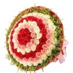 Rainbow Colors Bouquet featuring red, pink, and white roses arranged in a circular pattern with green foliage accents