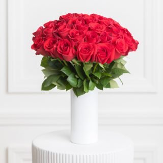 Send heartfelt sentiments with our 'Thinking of You' red flower vase. A stunning arrangement of 40 vibrant stems is elegantly displayed in a vase.