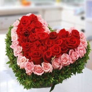 Winter Grace arrangement with red and pink roses, greenery's in a heart shaped flower box delivery in Nairobi Kenya
