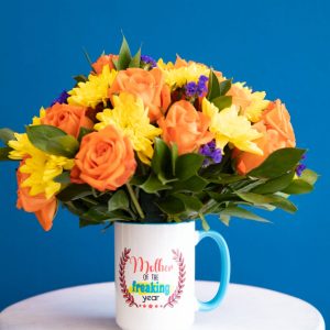 Celebrate the amazing moms in your life with this cheerful Mother of the Year mug arrangement. This unique gift is perfect for Mother's Day or any special occasion, featuring a message on the mug, fresh orange roses, yellow chrysanthemums, and purple accents. Enjoy Same-day flower delivery in Nairobi.