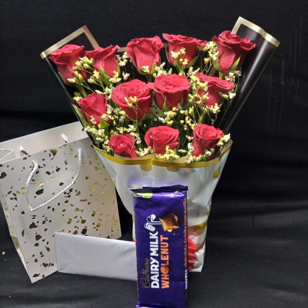 A red roses bouquet with delicate fillers, paired with Cadbury Dairy Milk Whole Nut chocolate, wrapped in elegant paper.