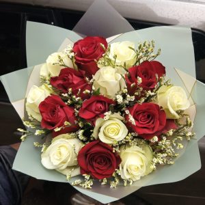 A bouquet of 20 red and white roses with delicate fillers, wrapped in soft pastel paper, symbolizing loyalty, love, and devotion.