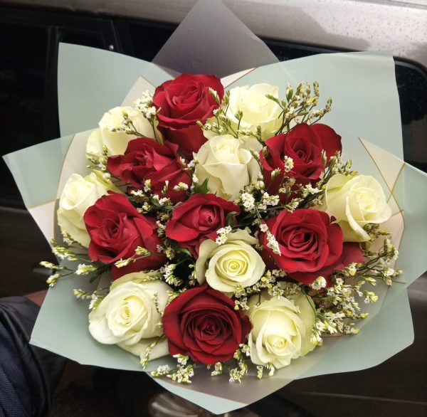 A bouquet of 20 red and white roses with delicate fillers, wrapped in soft pastel paper, symbolizing loyalty, love, and devotion.