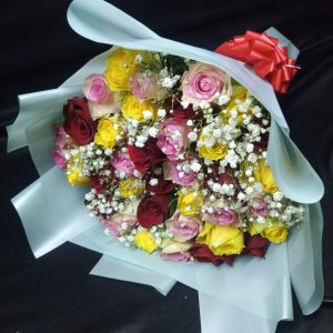 A bouquet of pink, yellow, and red roses complemented by delicate baby’s breath, creating a romantic and vibrant floral display.