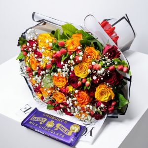 Whimsical Wonder Bouquet with red and yellow roses, hypericum, baby's breath and Cadbury chocolate