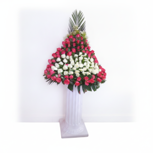 Standing bouquet arrangement with red and white roses in a triangular design and tall tropical foliage in Nairobi Kenya.