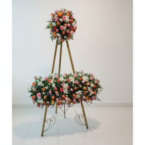 Standing floral arrangement with pink, orange, red and white flowers and greenery for events in Nairobi Kenya.